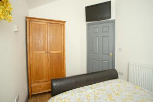 a room with a bed and a wooden cabinet at Willow Cottage a quaint holiday cottage in Wigtoft Boston Lincolnshire in Boston