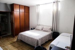 a small bedroom with a bed and a cabinet at Hotel Recanto do Sossego in Uberlândia