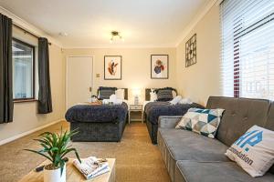 een woonkamer met een bank en een tafel bij Two Bedroom Bungalow in Milton Keynes with SKY TV, Free WiFi & Parking by HP Accommodation in Milton Keynes