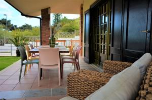 a patio with a table and chairs on a patio at Villa Settimia a 50 mt dalla spiaggia! in Àrbatax