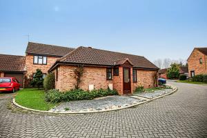 a brick house on a street with a driveway at Two Bedroom Bungalow in Milton Keynes with SKY TV, Free WiFi & Parking by HP Accommodation in Milton Keynes