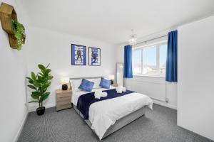 1 dormitorio con 1 cama con cortinas azules y ventana en Three Bedroom Home Near Central Milton Keynes by HP Accommodation with Free Parking, WiFi & Sky TV, en Milton Keynes