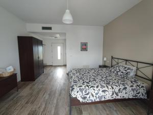 a bedroom with a bed and a wooden floor at Casale del Valla Agri B&B Naturista in Spigno Monferrato