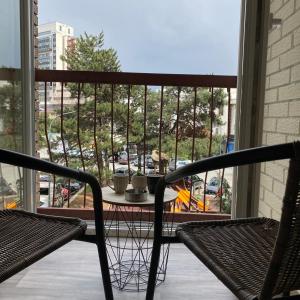 a balcony with two chairs and a table and a window at Rita Apartment in the heart of Pristina,Kosovo in Pristina