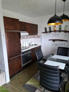 a kitchen with a table and some chairs in it at Seen- und Felsenland in Ludwigswinkel