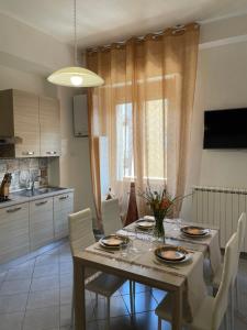 a dining room with a table and chairs and a kitchen at Appartamento Flaminia in Spoleto