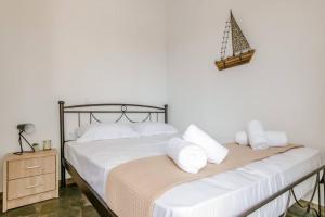 Una cama con sábanas blancas y almohadas en un dormitorio en Harmony Apartment 2, en Agios Sostis