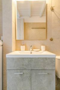 y baño con lavabo y espejo. en Harmony Apartment 2, en Agios Sostis