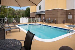 - une grande piscine avec des chaises et un parasol dans l'établissement Fairfield by Marriott Fort Walton Beach-Eglin AFB, à Shalimar
