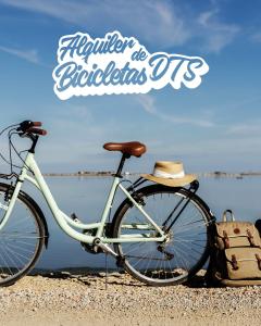 una bicicleta estacionada en la playa con un sombrero en Caseta De L'avi en Camarles
