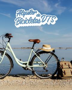 a bike parked on the beach with a hat on it at Caseta De L'avi in Camarles