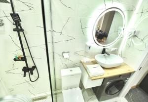 Un baño con ducha, lavabo y espejo. en Cozy room apartment, en Tiflis 20 fotos más