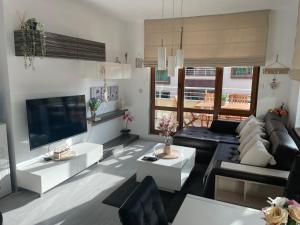 een woonkamer met een bank en een tv bij Апартамент La Тerrasse in Boergas