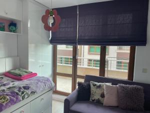 1 dormitorio con 1 cama, 1 silla y 1 ventana en Апартамент La Тerrasse, en Burgas