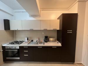 una cucina con armadi bianchi e piano cottura di Apartament Summerland Mamaia a Mamaia