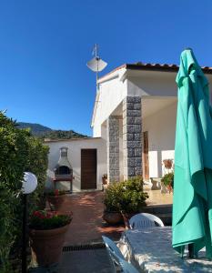 un patio con ombrellone e una casa di Villa Antonia a Marina di Campo