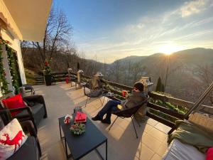 un hombre sentado en un patio con vistas a las montañas en VILA GIGI, ideala pentru relaxare si distractie! en Breaza