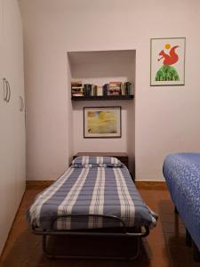 um pequeno quarto com uma cama com um colchão às riscas em La Terrazzina, silenzioso, zona Piazza Gran Madre em Turim