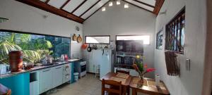 una cucina con tavolo e frigorifero di Casa da Floresta Pico da Águia a Parati