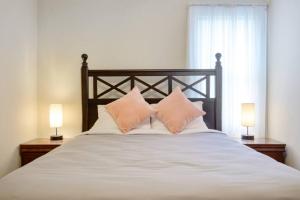 1 cama con 2 almohadas y 2 lámparas en Charming DT 3-Bed Bungalow with Fenced-in Yard en Raleigh