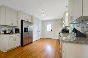 a kitchen with white cabinets and a wooden floor at Charming DT 3-Bed Bungalow with Fenced-in Yard in Raleigh