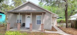 a small house with a chair in front of it at Modern House Minutes from Downtown Gainesville, UF, VA & More! in Gainesville