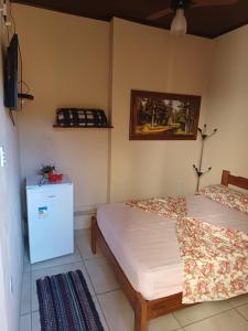a bedroom with two beds and a tv on the wall at Pousada Castro in Aparecida