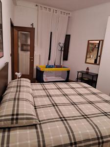 een slaapkamer met een bed met een geruite deken bij La Terrazzina, silenzioso, zona Piazza Gran Madre in Turijn