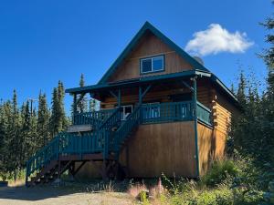 Aurora Ridge Cabin في فيربانكس: كابينة خشبية كبيرة مع شرفة كبيرة