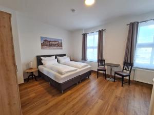 una camera con un letto e un tavolo e due sedie di Hotel Gleis 3viertel Jena a Jena