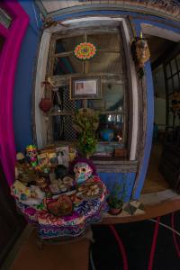 Cette chambre comprend une table avec des poupées et un miroir. dans l'établissement Bichon La Casa Hostal, à Pichilemu