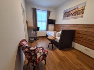 ein Wohnzimmer mit einem Sofa und einem Stuhl in der Unterkunft Hotel Gleis 3viertel Jena in Jena