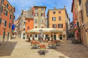 an empty street with tables and chairs and buildings at Casa Polo in Rovinj