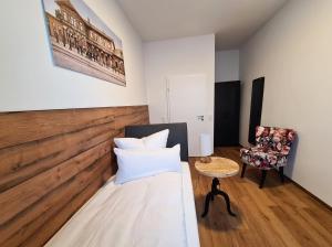 a small room with a bed and a chair at Hotel Gleis 3viertel Jena in Jena