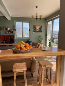 a kitchen with a table with a bowl of fruit at Glass house in Ulcinj
