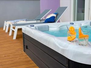 AstraMaris Znjan - Deluxe beach suite with hot tub في سبليت: حوض استحمام ساخن مع كأسين من شرائح البرتقال عليه