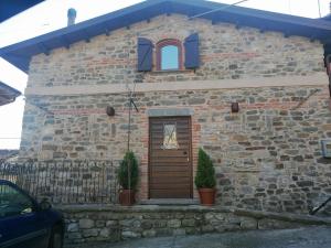 una casa de ladrillo con puerta y ventana en Villa Maria, en Bagnone
