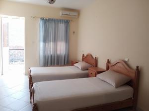 two beds in a room with a window at Auberge Les Montagnes du Paradis in Agadir