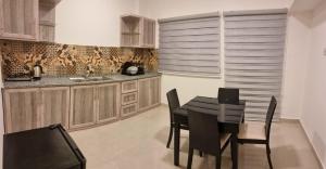 eine Küche mit einem Tisch und Stühlen im Zimmer in der Unterkunft Byblos Deluxe in Aqaba