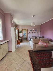 a living room with pink walls and a couch at Casa Marisa in Verbania