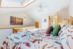 a bedroom with a bed with a comforter and pillows at Nordic Wilderness Lodge in Bartlett