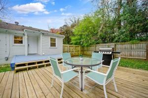 a patio with a table and chairs and a grill at Cozy 3 Bedroom Cottage with Huge Fenced-In Yard in Raleigh