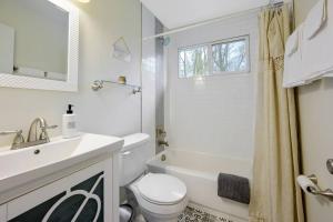 a white bathroom with a sink and a toilet at Cozy 3 Bedroom Cottage with Huge Fenced-In Yard in Raleigh