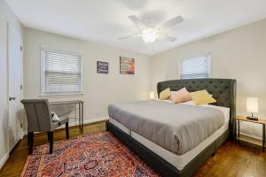 um quarto com uma cama, uma mesa e uma cadeira em Cozy 3 Bedroom Cottage with Huge Fenced-In Yard em Raleigh