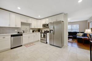 a kitchen with white cabinets and stainless steel appliances at Cozy 3 Bedroom Cottage with Huge Fenced-In Yard in Raleigh