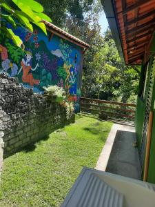 a wall with a mural on the side of a house at venha curtir a natureza in Nova Friburgo