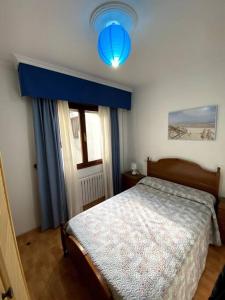 ein Schlafzimmer mit einem Bett und einem blauen Licht in der Unterkunft Vivienda de Uso turístico Paseo del Suaron Vegadeo in Vegadeo