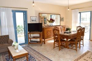 a living room with a table and a television at Μπουκαμβίλια/Bougainvillea tree in Vaia