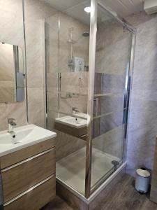 uma casa de banho com um chuveiro e um lavatório. em Kings Boutique Hotel em Blackpool