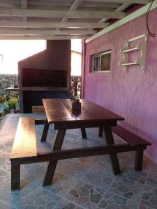 a wooden picnic table and bench on a patio at Cabañas Punta Palmar (Casa 3) in Punta Del Diablo
